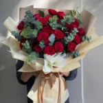 A bouquet of red roses and eucalyptus